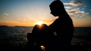 Photo of a woman sitting in the sunset. For grief counseling contact Mason today.